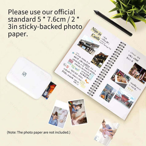 MT53 portable photo printer with sticky-backed photos on a scrapbook page, demonstrating printing setup.