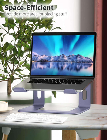 Aluminum laptop stand with a laptop displaying a scenic background, designed to be space-efficient for desk organization.